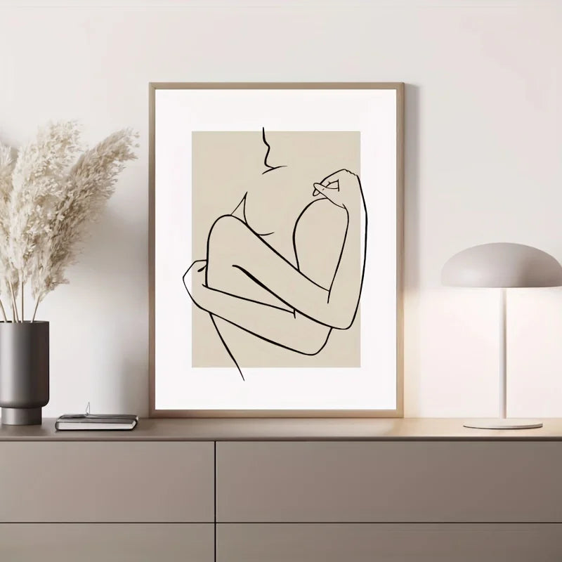 Framed line art print of a nude figure on a wall above a cabinet.