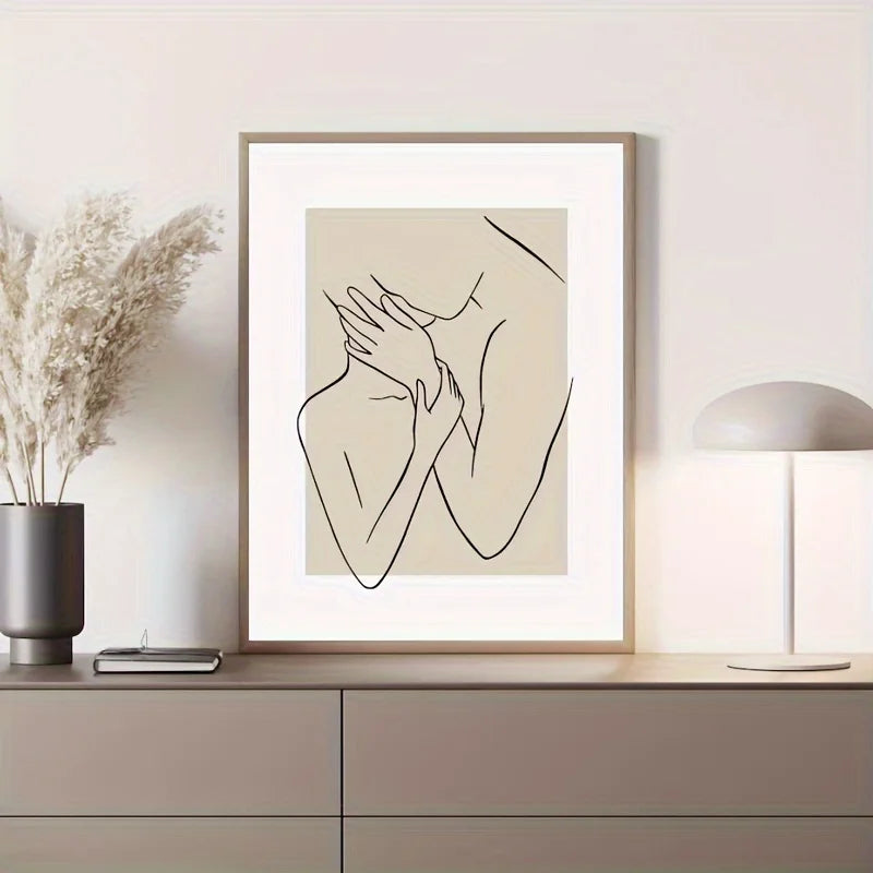 Framed line art print of hands on a wall above a cabinet with decor items.