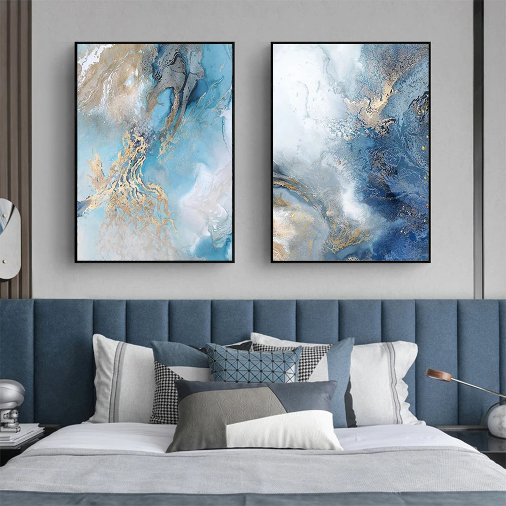 Two abstract art pieces on a wall above a bed with decorative pillows.
