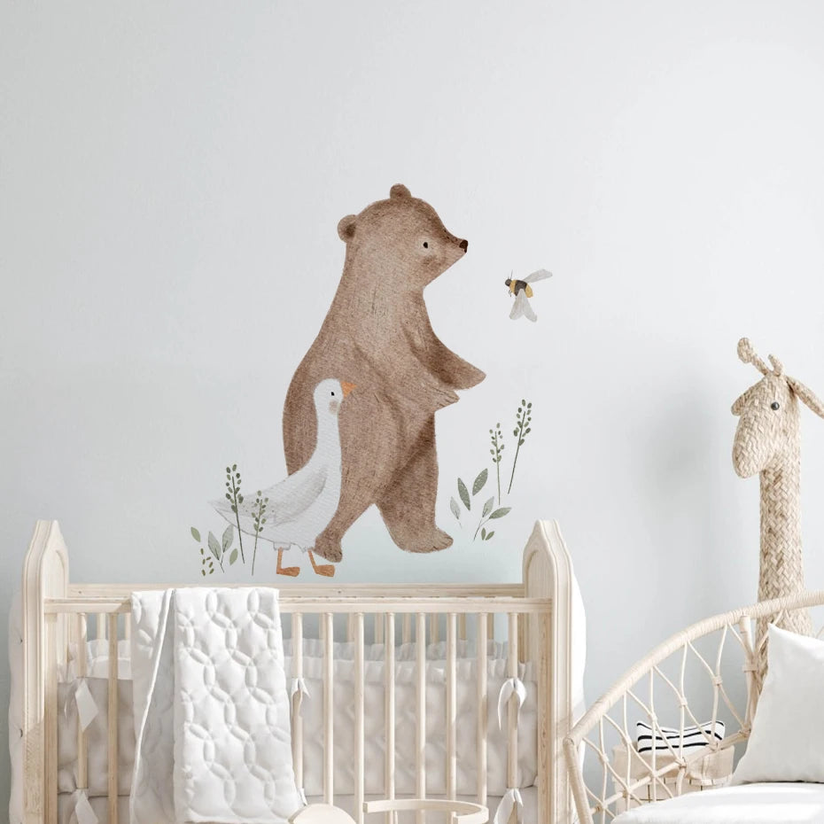 Children's room with a bear and goose wall decal above a crib.