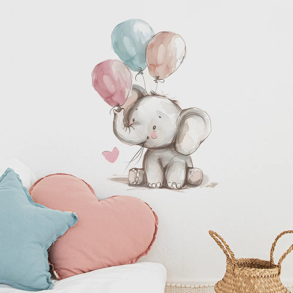 Wall decal of an elephant holding balloons on a wall with decorative pillows and a basket below.