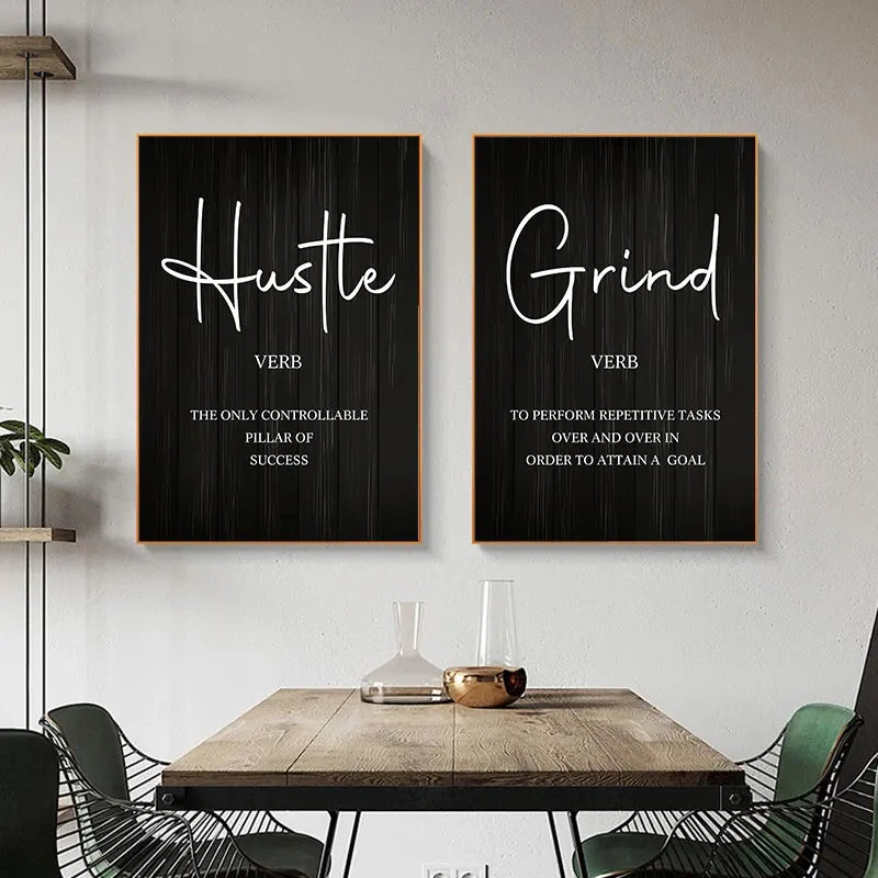 Two framed prints on a wall with motivational phrases 'Hustle' and 'Grind'.