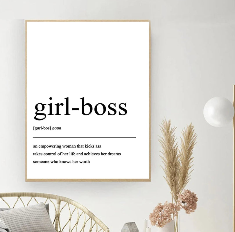 Framed print with 'girl-boss' definition on a wall with decor elements.