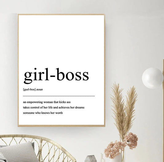 Framed print with 'girl-boss' definition on a wall with decor elements.