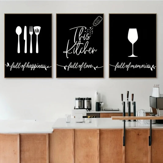 Three black framed prints with white text and icons on a wall above a kitchen counter.
