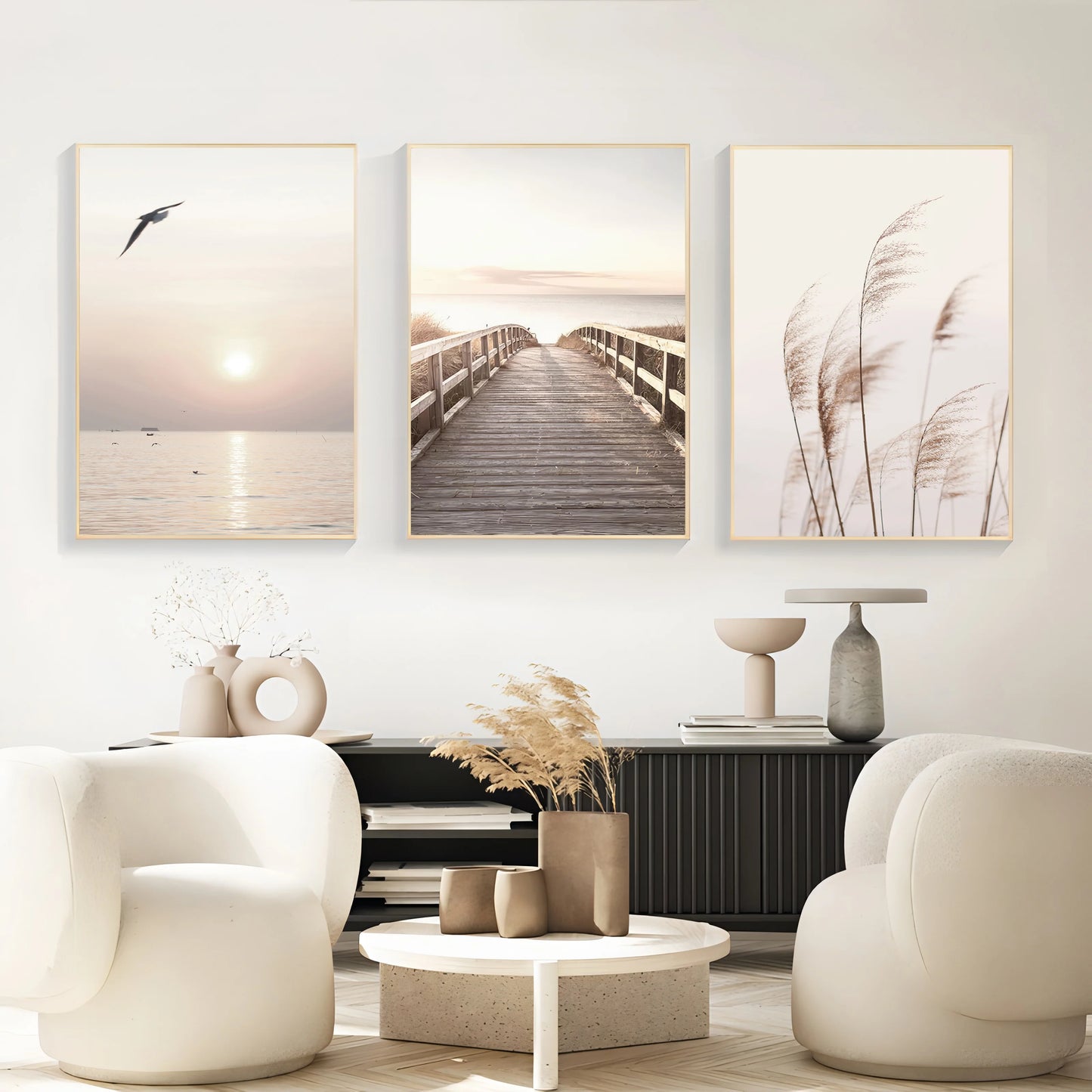 Modern living room with three framed artworks on the wall, white chairs, and a coffee table.