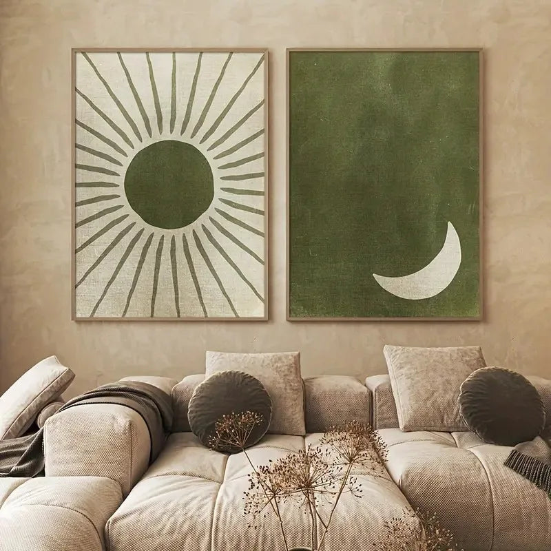 Two framed artworks on a wall above a beige sofa with decorative pillows.