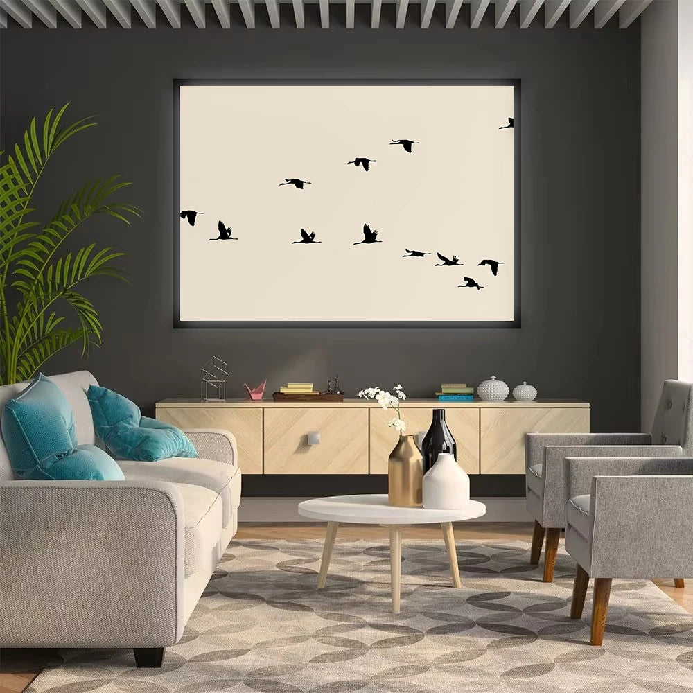 Modern living room with gray sofa, armchair, and coffee table, featuring a wall art of black birds.