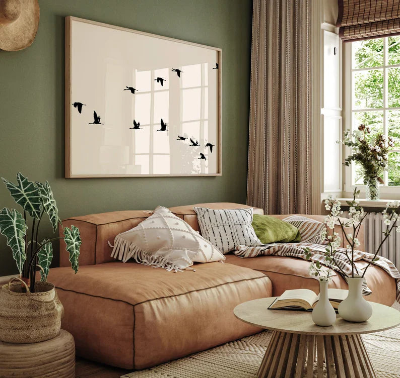 Cozy living room with a brown sofa, decorative pillows, and a framed artwork on a green wall.