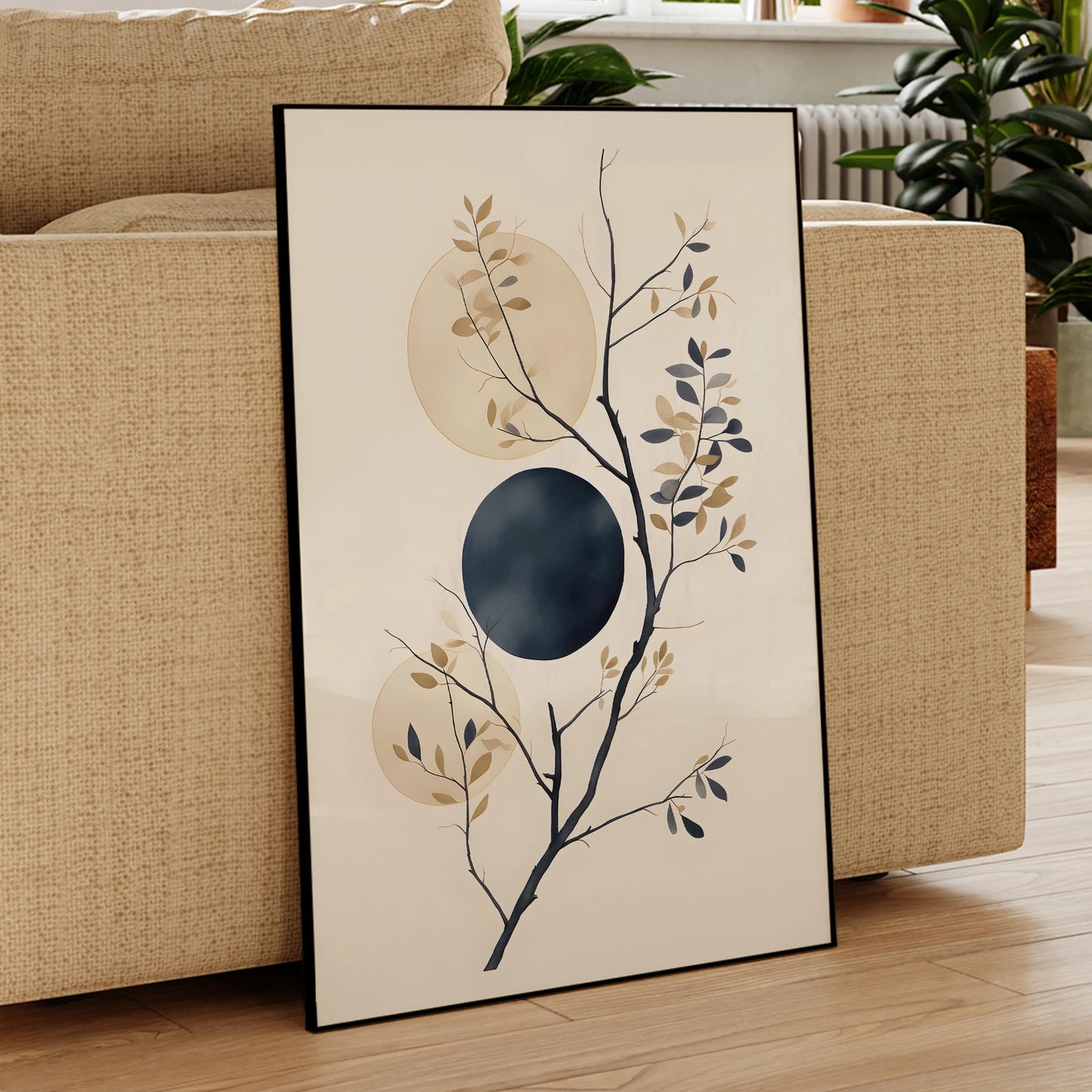 Framed abstract art piece leaning against a beige sofa in a living room.