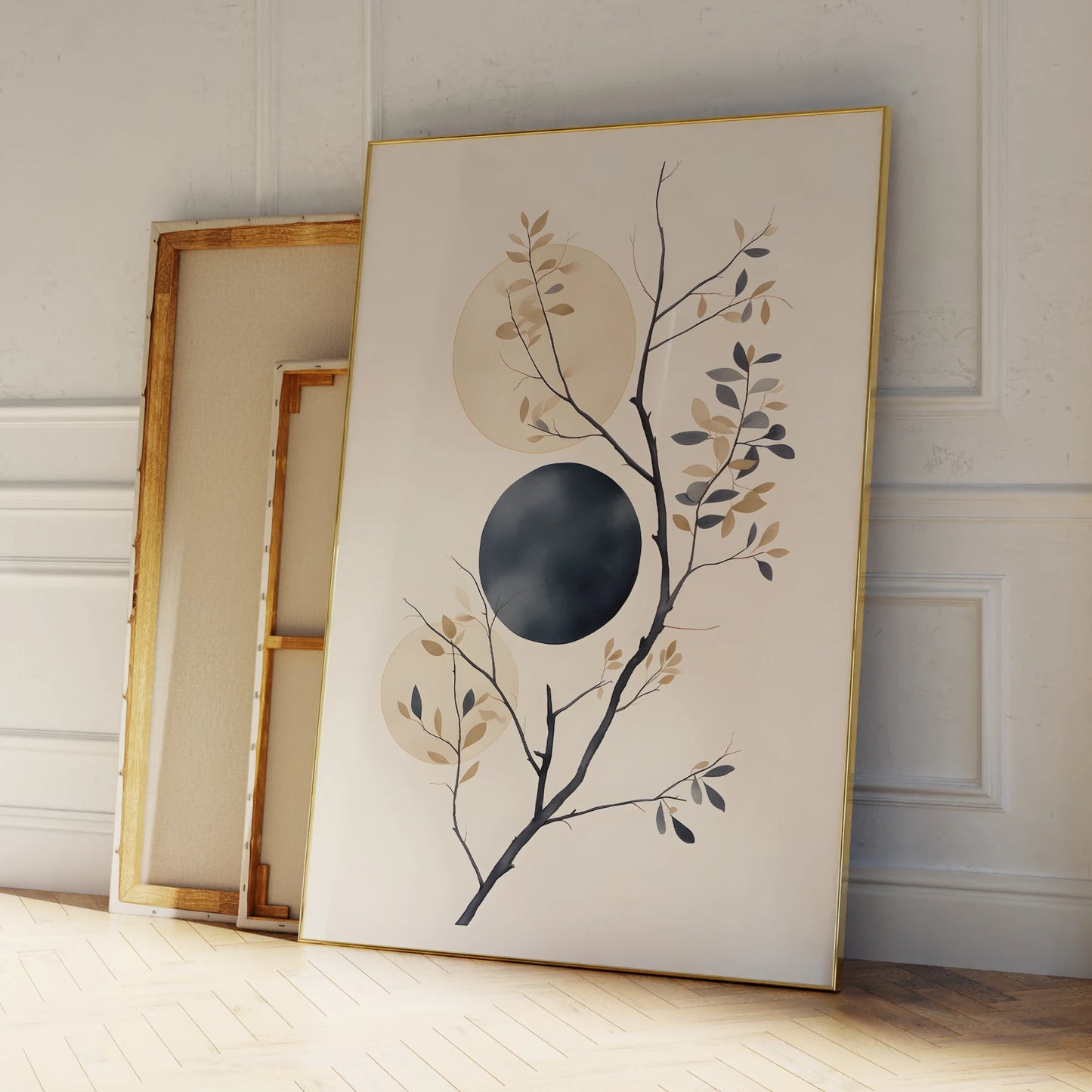 Framed artwork with a branch and circular design leaning against a wall.