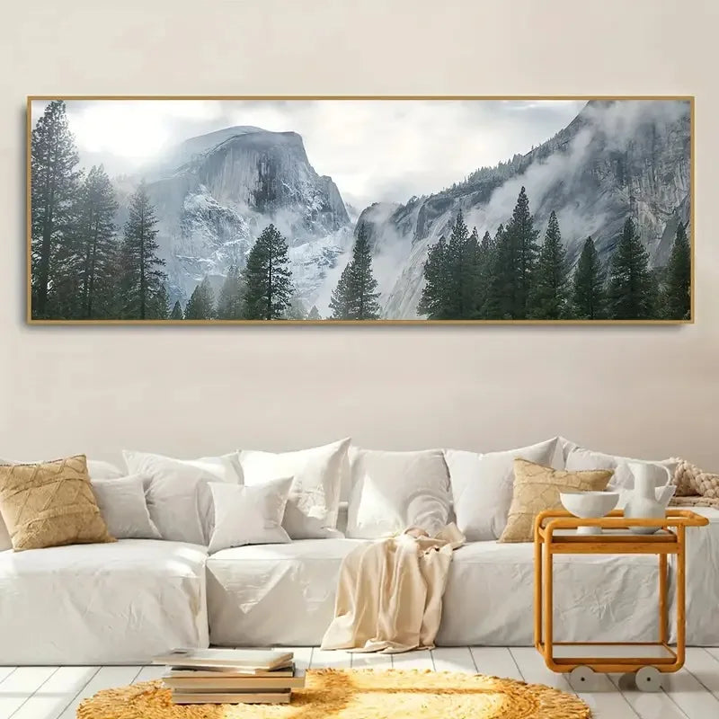 Framed mountain landscape art above a white sofa in a living room.