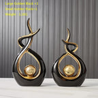 Two black and gold decorative items on a white surface with a gray background