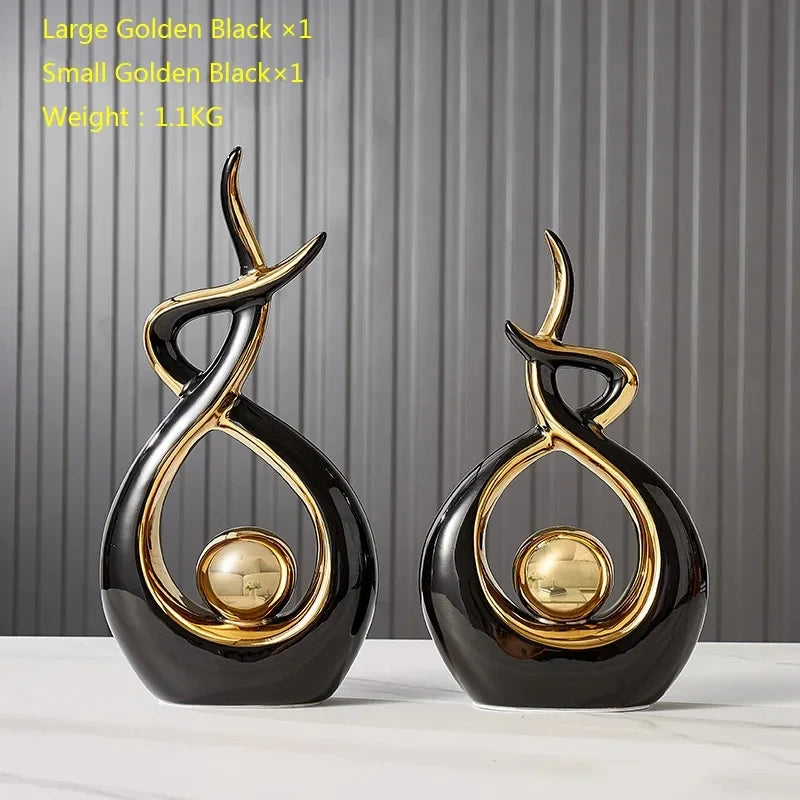 Two black and gold decorative items on a white surface with a gray background