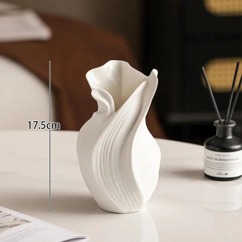 White ceramic vase on a table with a measurement label indicating its height.