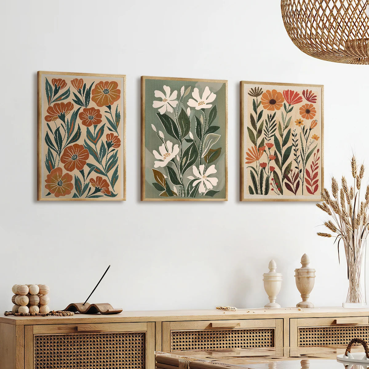 Three floral wall art pieces above a wooden console table with decorative items.