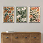Three floral art prints above a wooden console table on a plain wall.