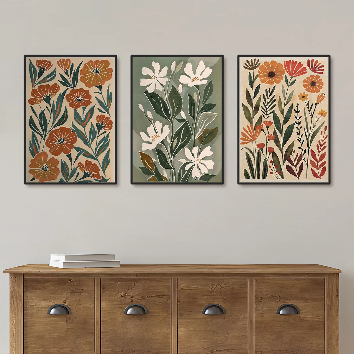 Three floral art prints above a wooden console table on a plain wall.