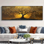A large wall art piece featuring a stylized tree with golden-yellow foliage and a glowing yellow sun behind it, displayed above a modern light gray sofa with decorative pillows in a living room setting.
