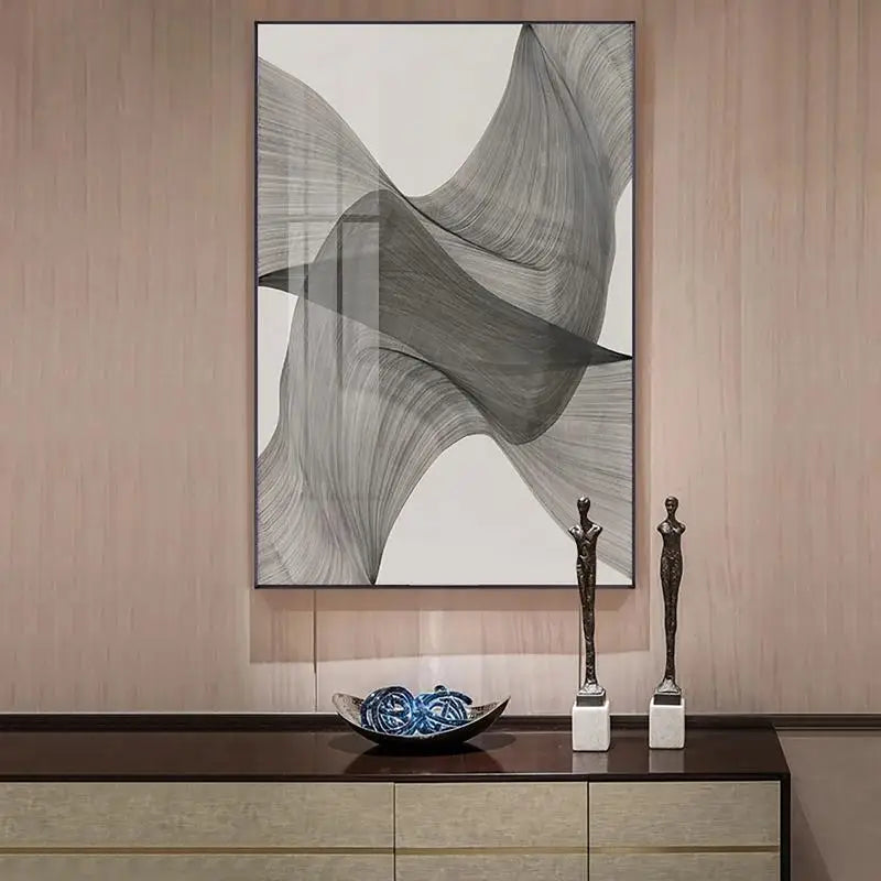 Abstract art piece on a wall above a console table with decorative items.