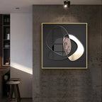 Modern abstract wall art piece on a textured wall in a room with a shelf and stool.