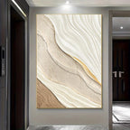 Abstract wall art with wavy patterns in neutral colors on a gray wall.