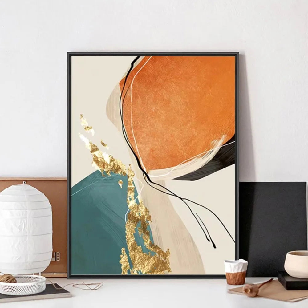 Abstract art print with orange, blue, and gold colors in a black frame on a wall.