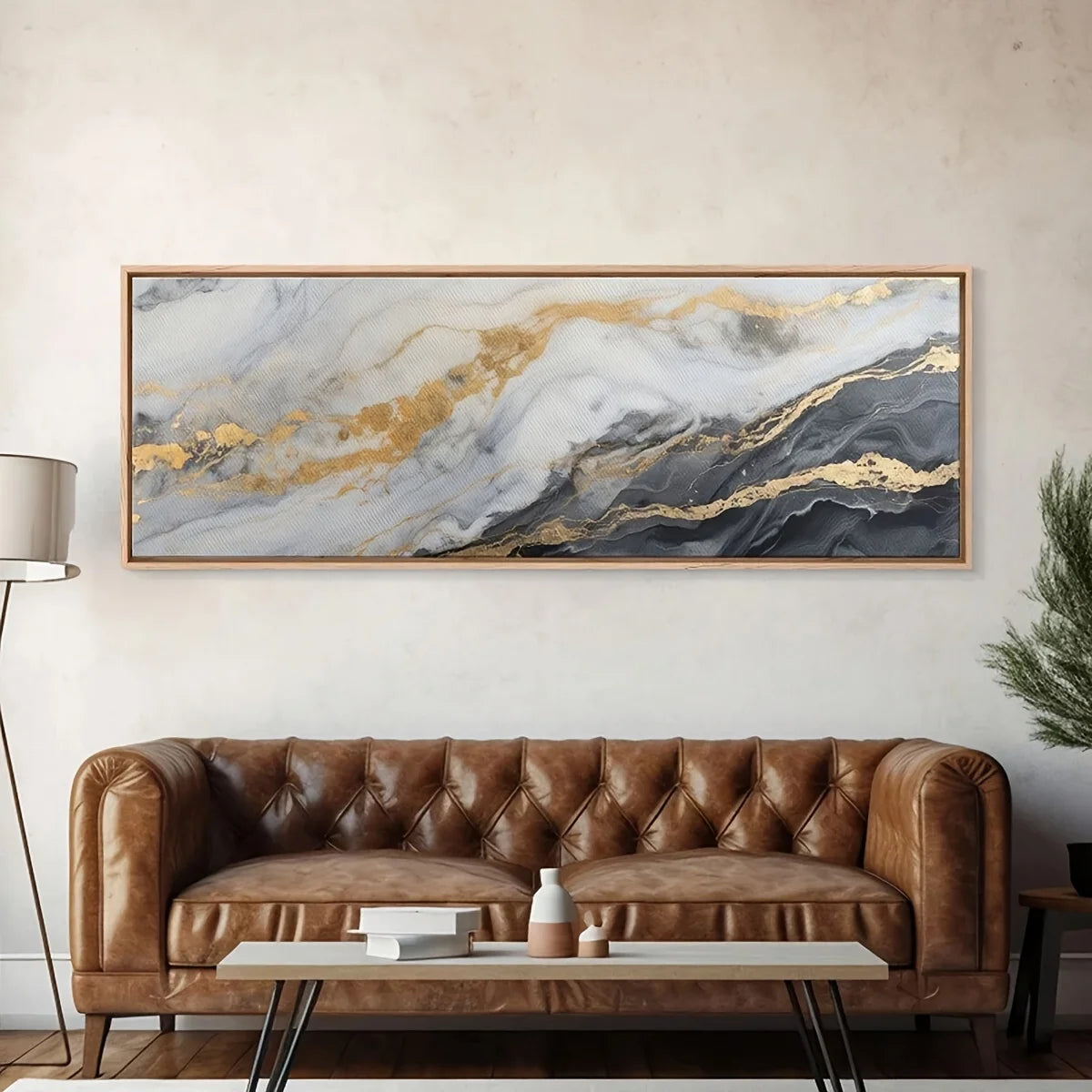 Brown leather sofa in a living room with a large abstract painting above it.