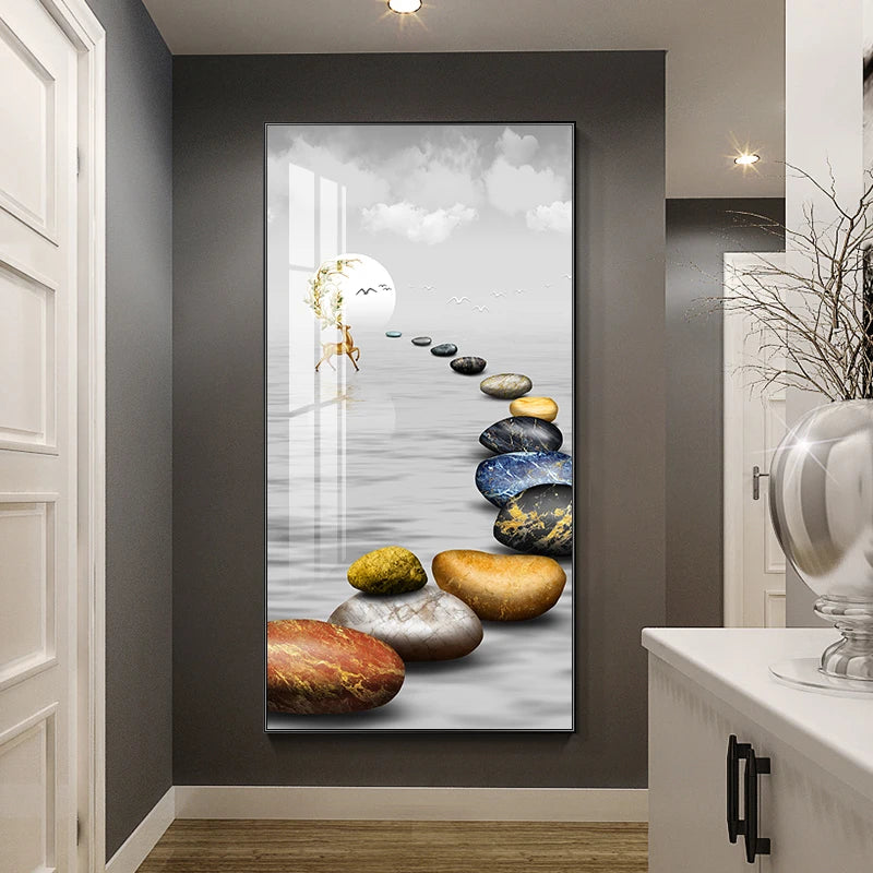 Framed artwork of stones leading to a light source on a gray wall.