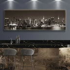 Panoramic cityscape artwork on a wall above a bar with stools.