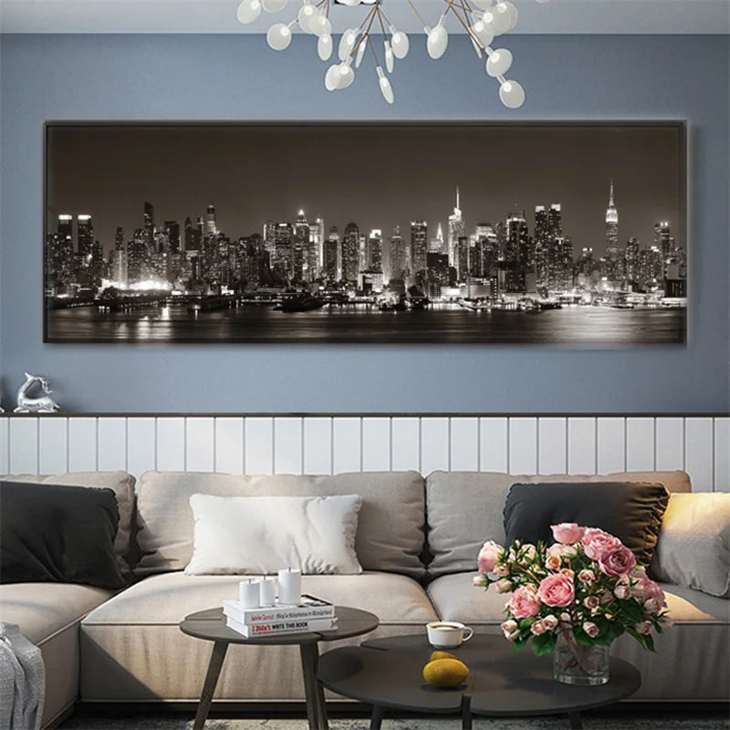 Living room with a large wall art of a city skyline, sofa, and coffee table with a vase of flowers.