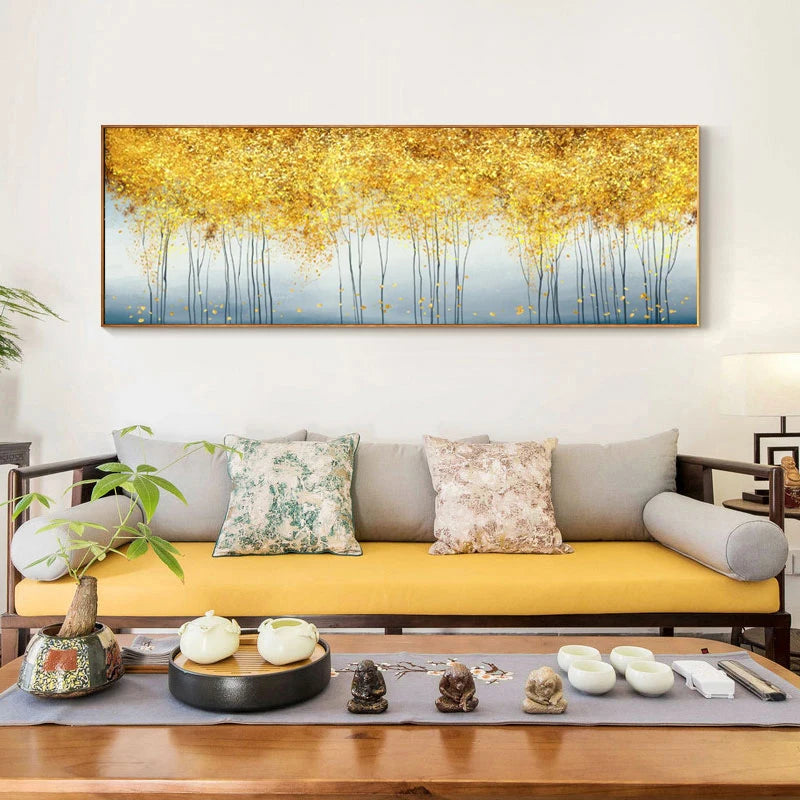 Decorative painting of a golden forest above a sofa with decorative items on a table.