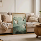 Living room with a beige sofa, decorative pillows, and a framed artwork of cranes on a mountainous landscape.
