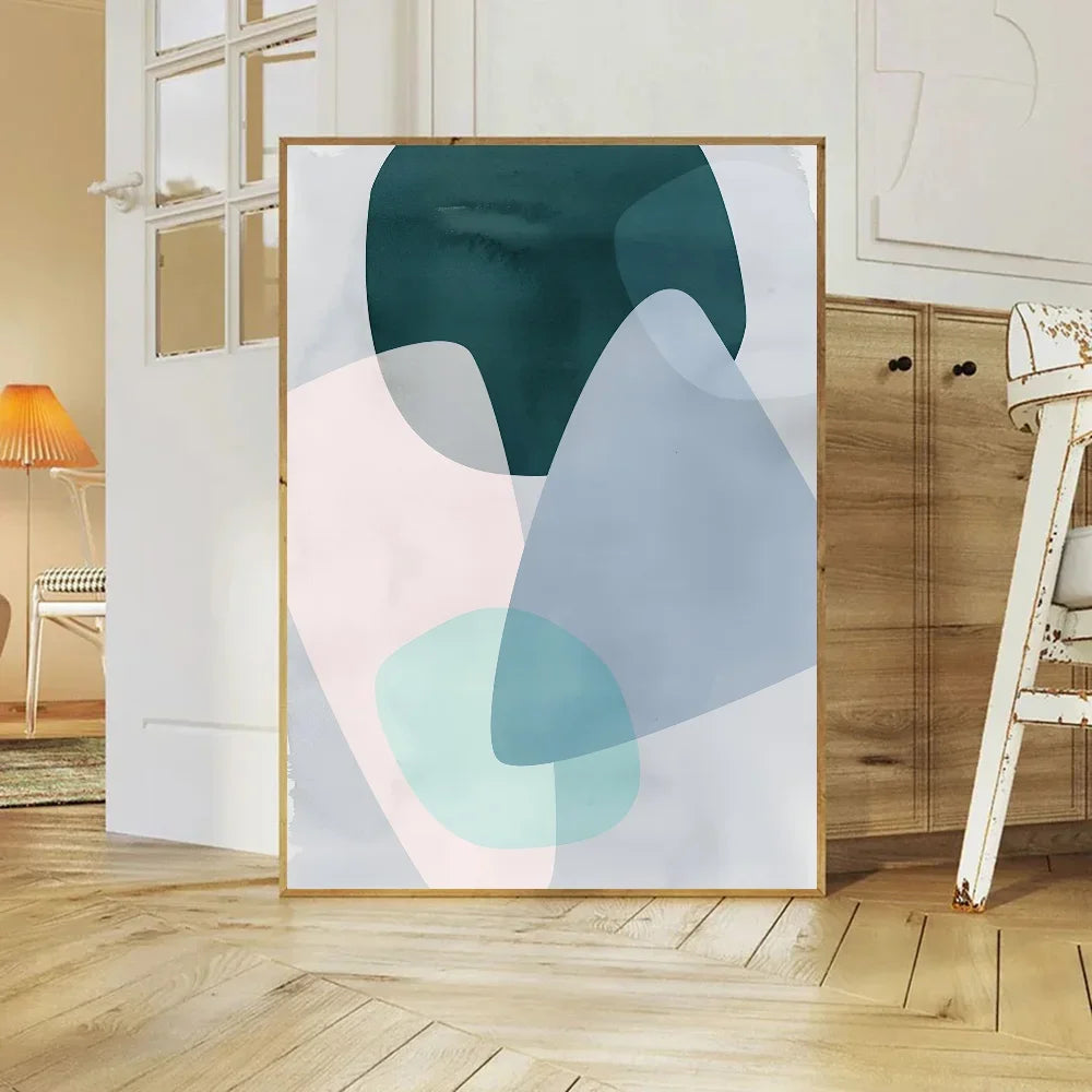 Abstract art print in a gold frame on a wall in a room with wooden flooring and furniture.