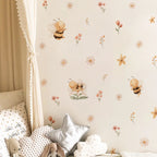 Children's room with wallpaper featuring bees and flowers, pillows, and a curtain.