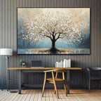 Decorative painting of a tree on a wall above a desk with books and a laptop.