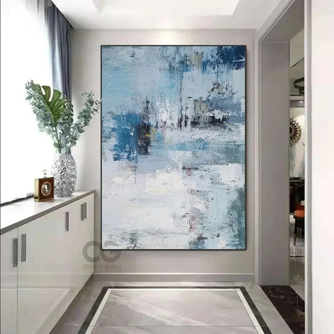 Abstract painting in a modern interior setting with a cabinet and decorative items.