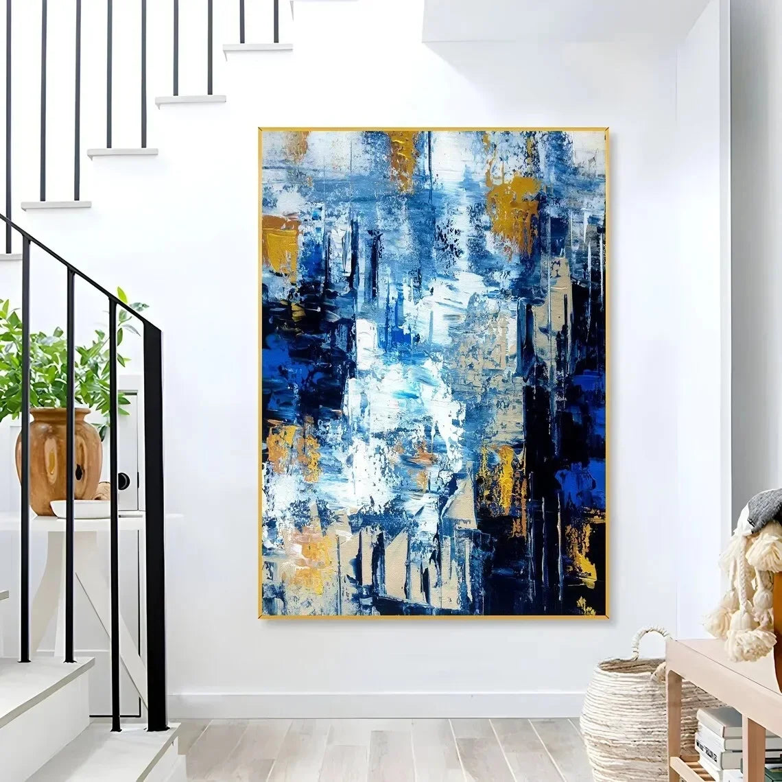 Abstract painting with blue and gold tones in a modern interior setting.