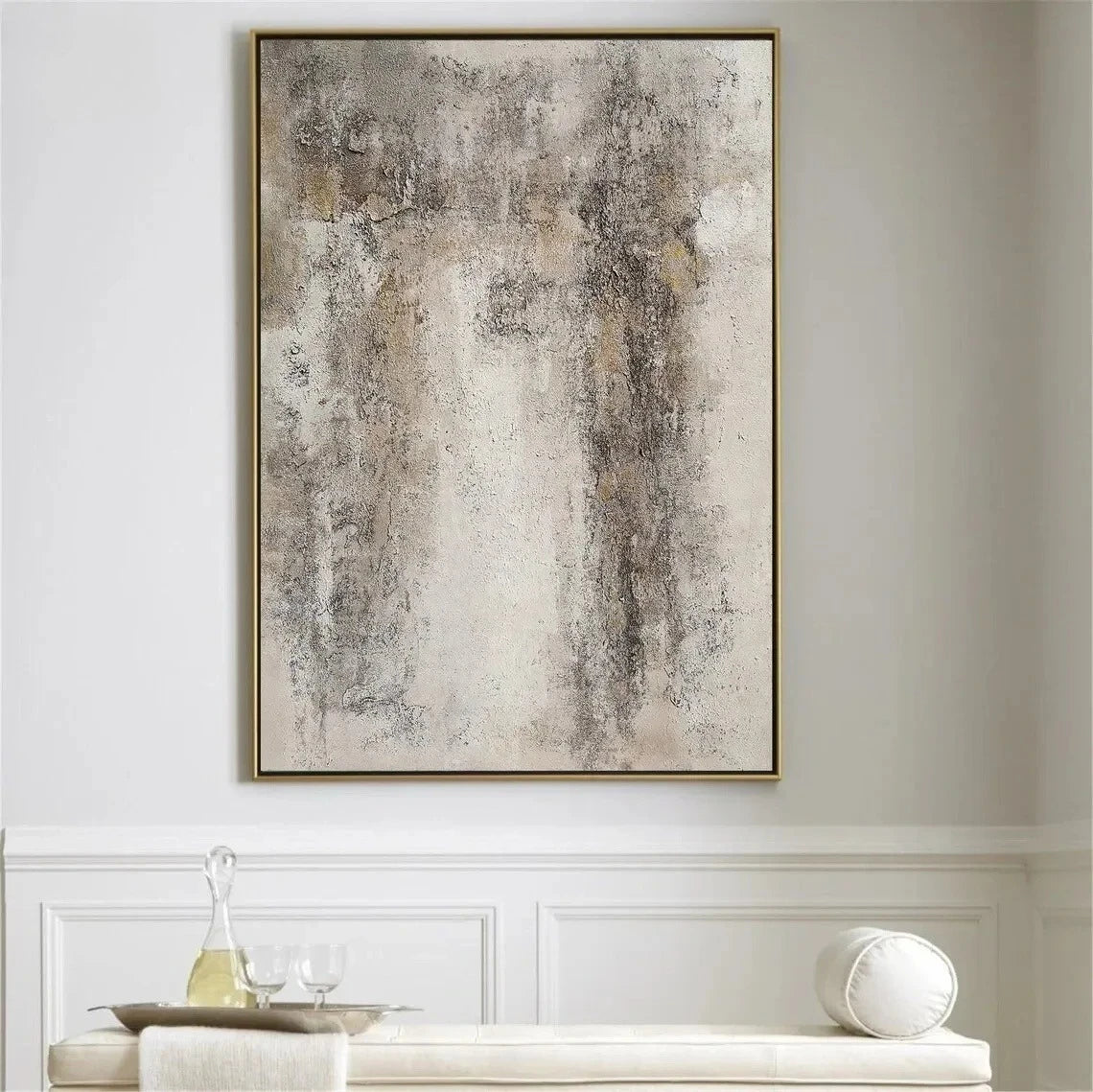Abstract painting in a gold frame on a wall above a white console table.
