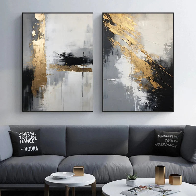 Two abstract art pieces on a wall above a gray sofa with decorative pillows.