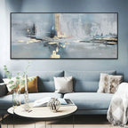 Living room with a gray sofa, round coffee table, and abstract painting on the wall.