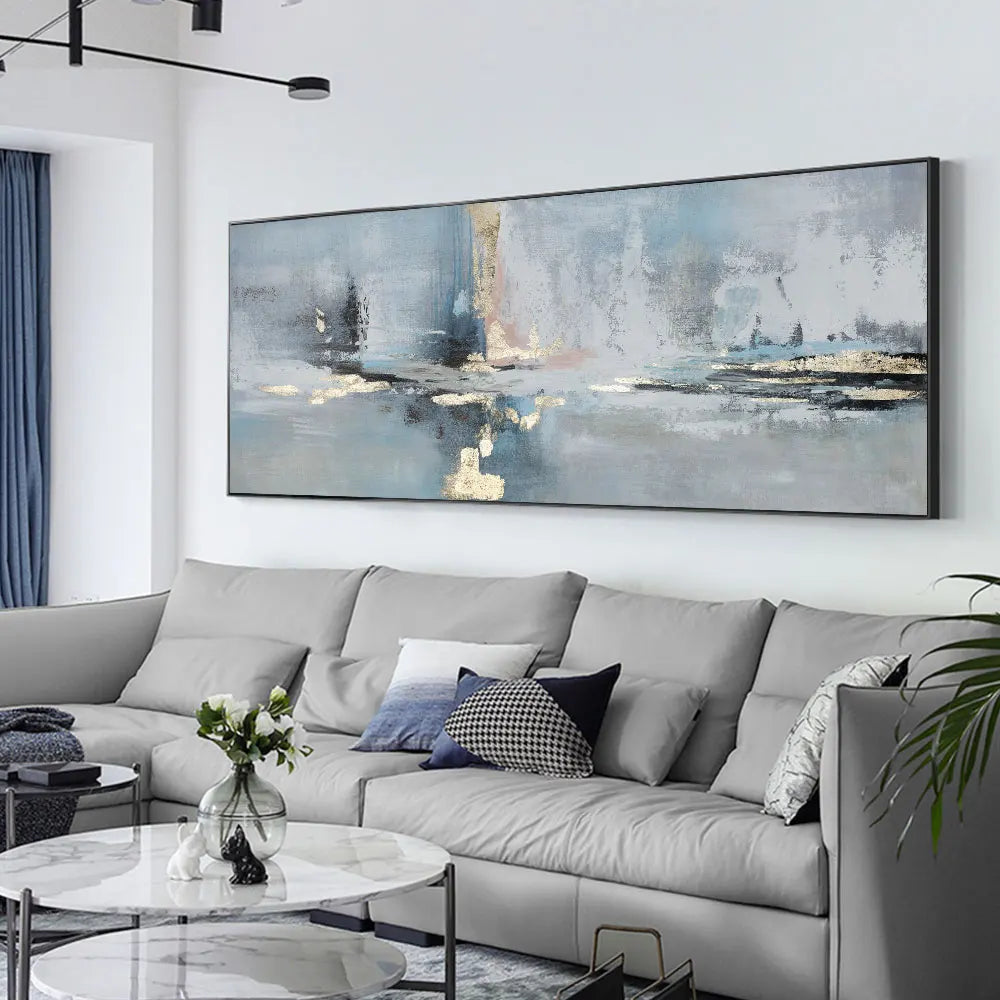 Living room with a gray sectional sofa, abstract painting, and decorative elements.