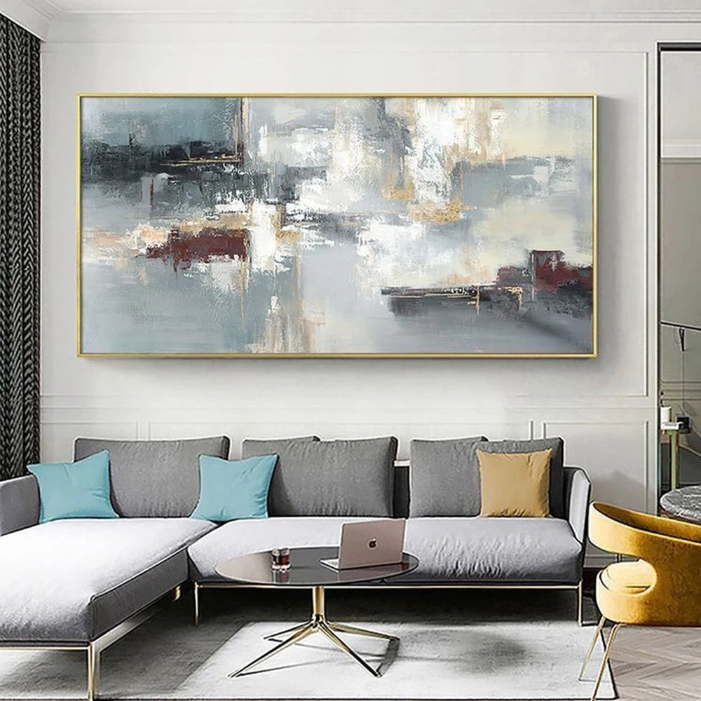Modern living room with a large abstract painting on the wall, a gray sectional sofa, and a round coffee table.
