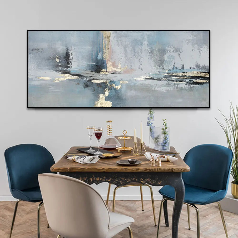 Dining room with a wooden table set for a meal, blue chairs, and abstract art on the wall.