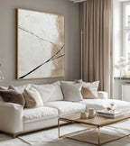 Modern living room with a white sofa, abstract painting, and gold coffee table.