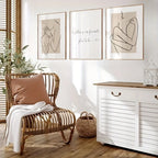 Nursery room with wicker chair, white dresser, and framed artwork on the wall.
