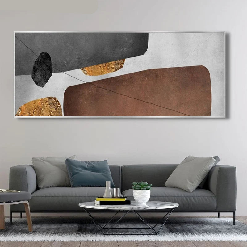 Abstract art piece on a wall above a gray sofa in a living room.