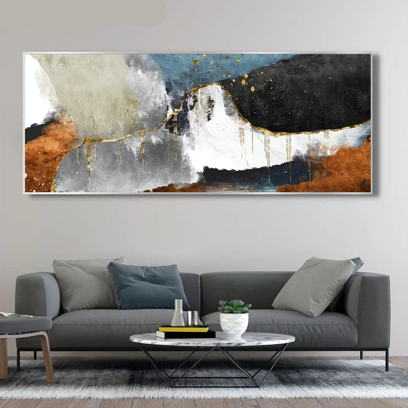 Abstract art painting on a wall above a gray sofa in a living room.