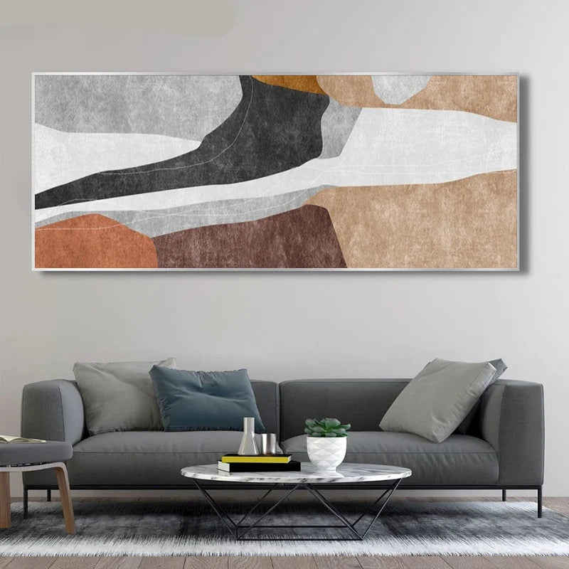 Abstract art piece on a wall above a gray sofa in a living room.