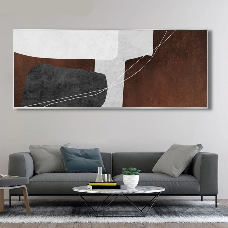 Abstract art piece on a wall above a gray sofa in a living room.